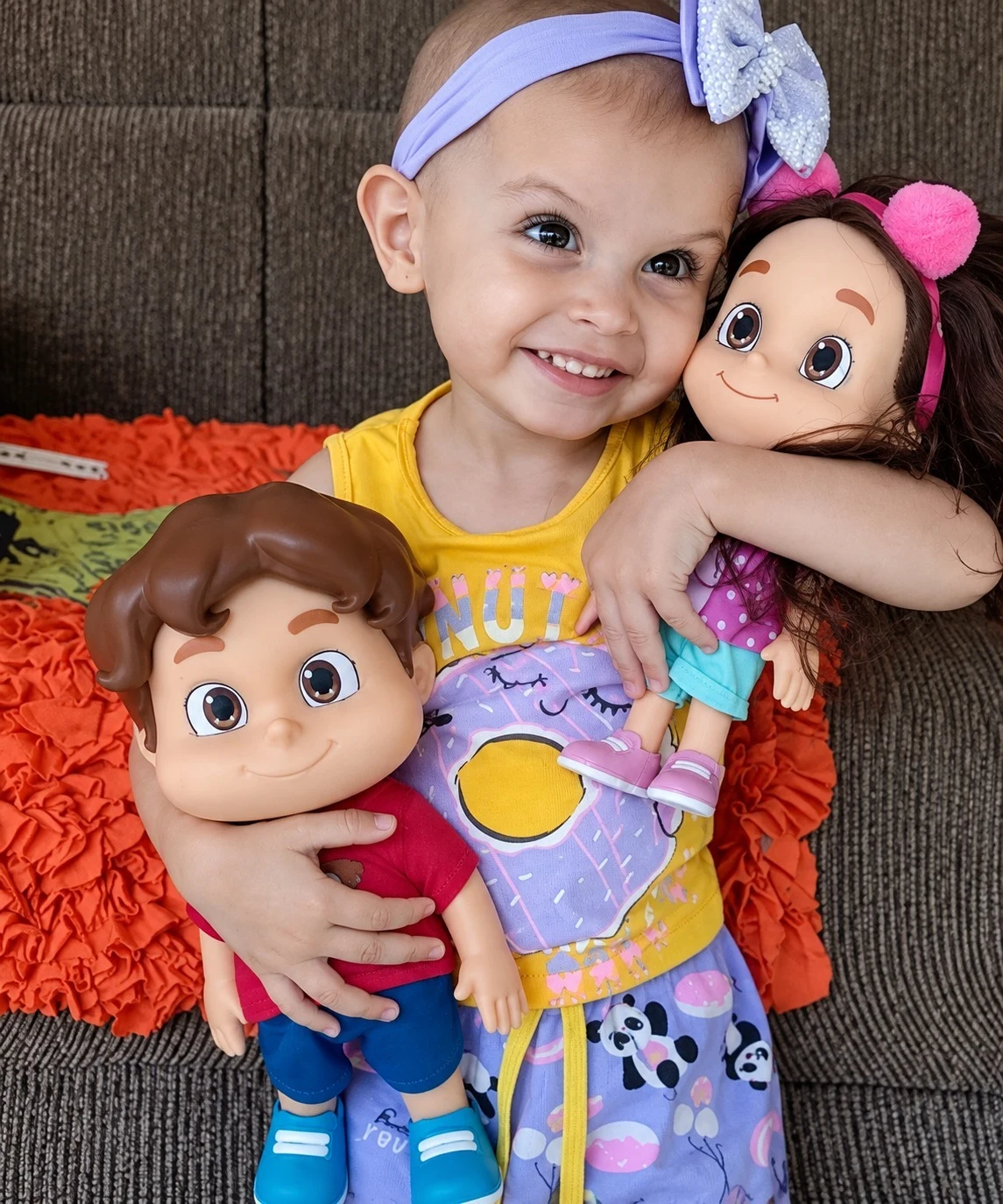 Eloísa sorrindo com seus bonecos
